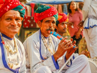 pexels-photo-15634341-15634341 Colorful Rajasthani musicians playing traditional instruments outdoors, showcasing cultural heritage.